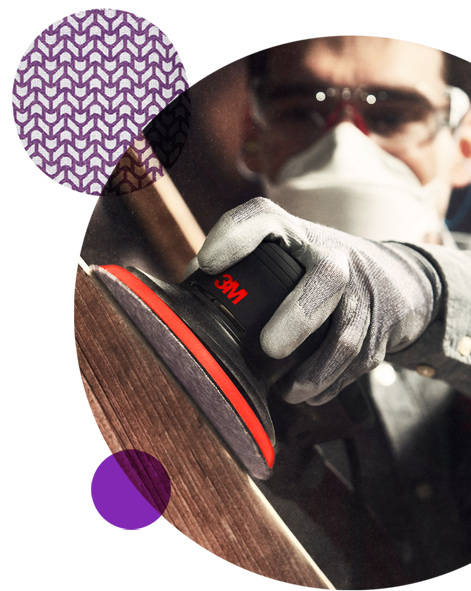 Man som använder en 3M slipmaskin på trä