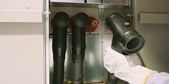 En arbetare använder 3M™ Cold Shrink-teknik för separerbara kopplingar med mellanspänning
