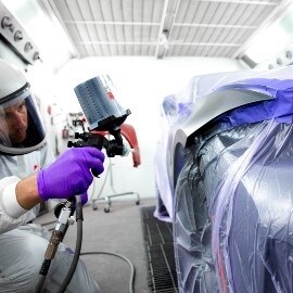 Lackerare som applicerar färg på bil med Performance-sprutpistol från 3M
