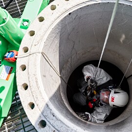 En medarbetare med 3M-hjälm i ett slutet utrymme