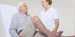 Läkare som talar med en patient som genomgår kompressionsbehandling
