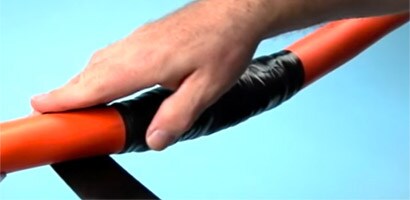 En man applicerar svart 3M tejp för att reparera en kabelmantel.
