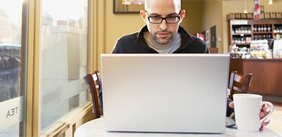 En person arbetar med en bärbar dator på allmän plats
