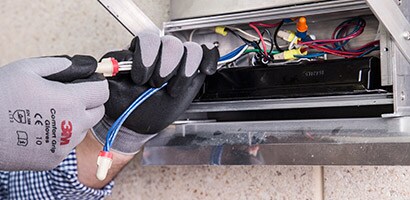 En man installerar elledning på med 3M tejp.
