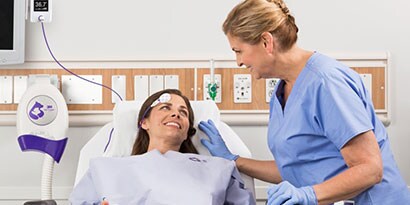 Sköterska som tar hand om en patient som bär en bairhugger (patientuppvärmningssystem)