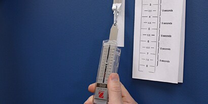 En person håller ett testinstrument för folievidhäftning från 3M
