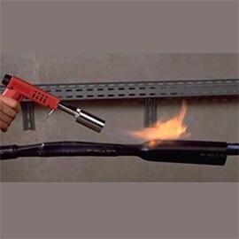 En arbetare som använder en flamfackla på eltejp