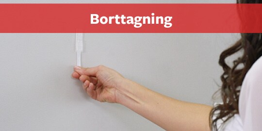 Kvinna tar bort kroken från väggen
