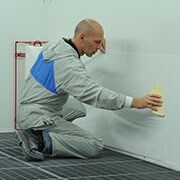 Applicering av Dirt Trap lackboxskydd på en vägg med en spridare