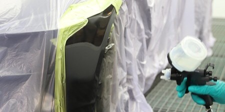 Tekniker polerar en karosseriplåt
