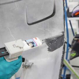 Använd en manuell pistol för att applicera flexibelt reparationsmaterial på sprickans baksida