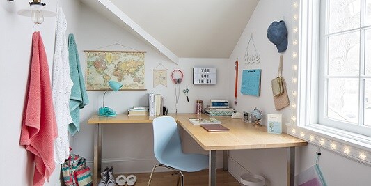 Studieområde med föremål som hålls uppe av krokar och strips från Command
