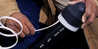 Händer som visar användningen av 3M Heat Shrink-ändlock
