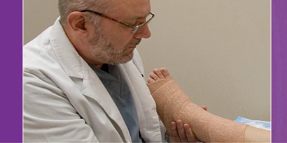 Läkare som applicerar en linda på en patient
