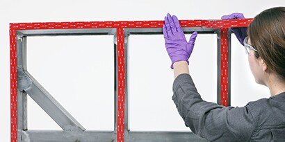 Tekniker som applicerar tejp vid sammanfogning av en panel mot ram
