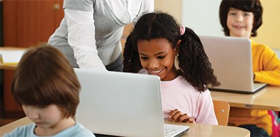 Barn i ett klassrum med bärbara datorer
